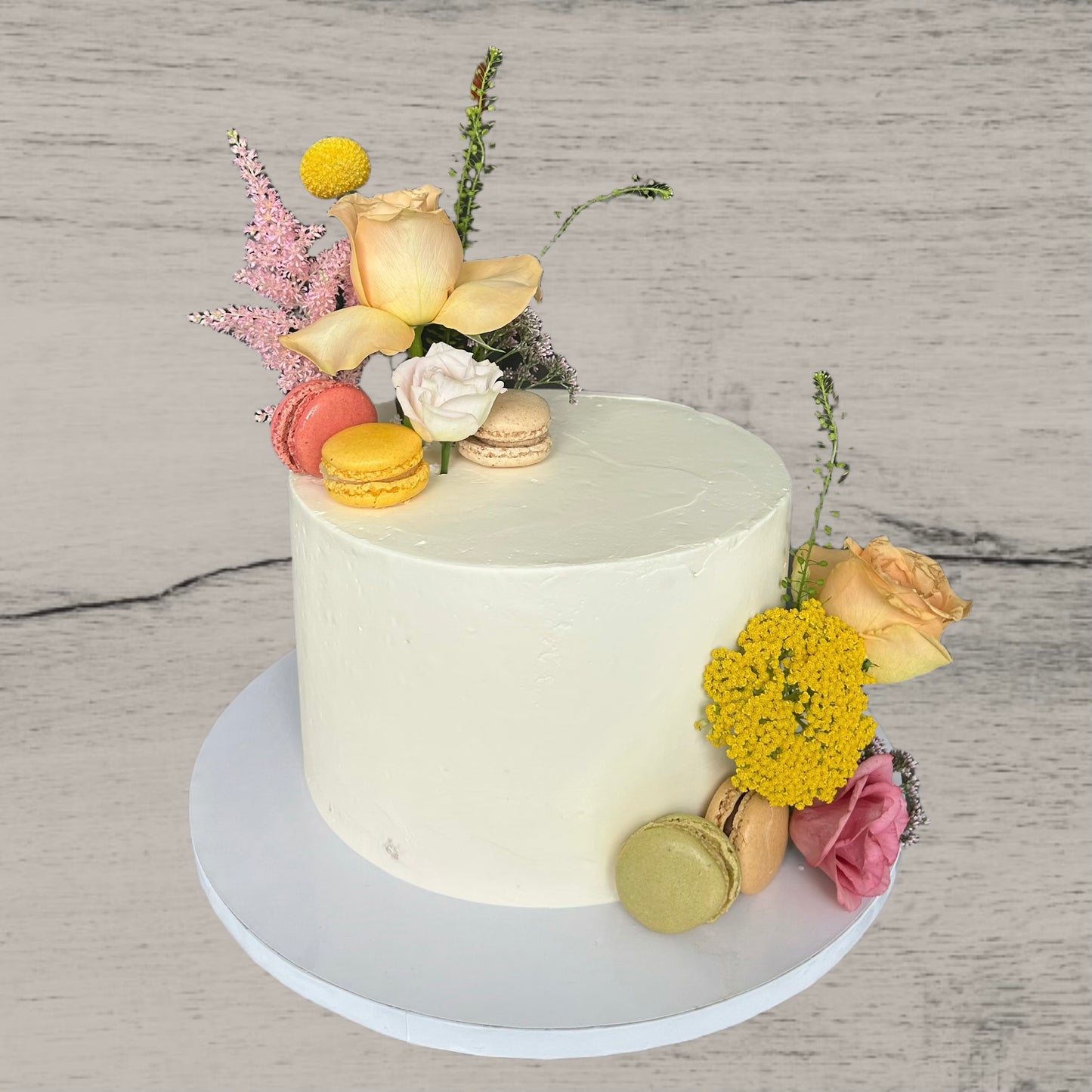 Hochzeitstorte mit Blumen und Macarons